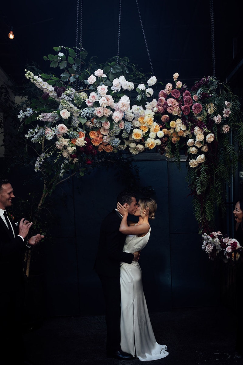 Newlywed-Couple-In-Front-of-Floral-Arbour-at-Rupert-on-Rupert-Wedding-Photographed-by-Fern-and-Stone-Photography