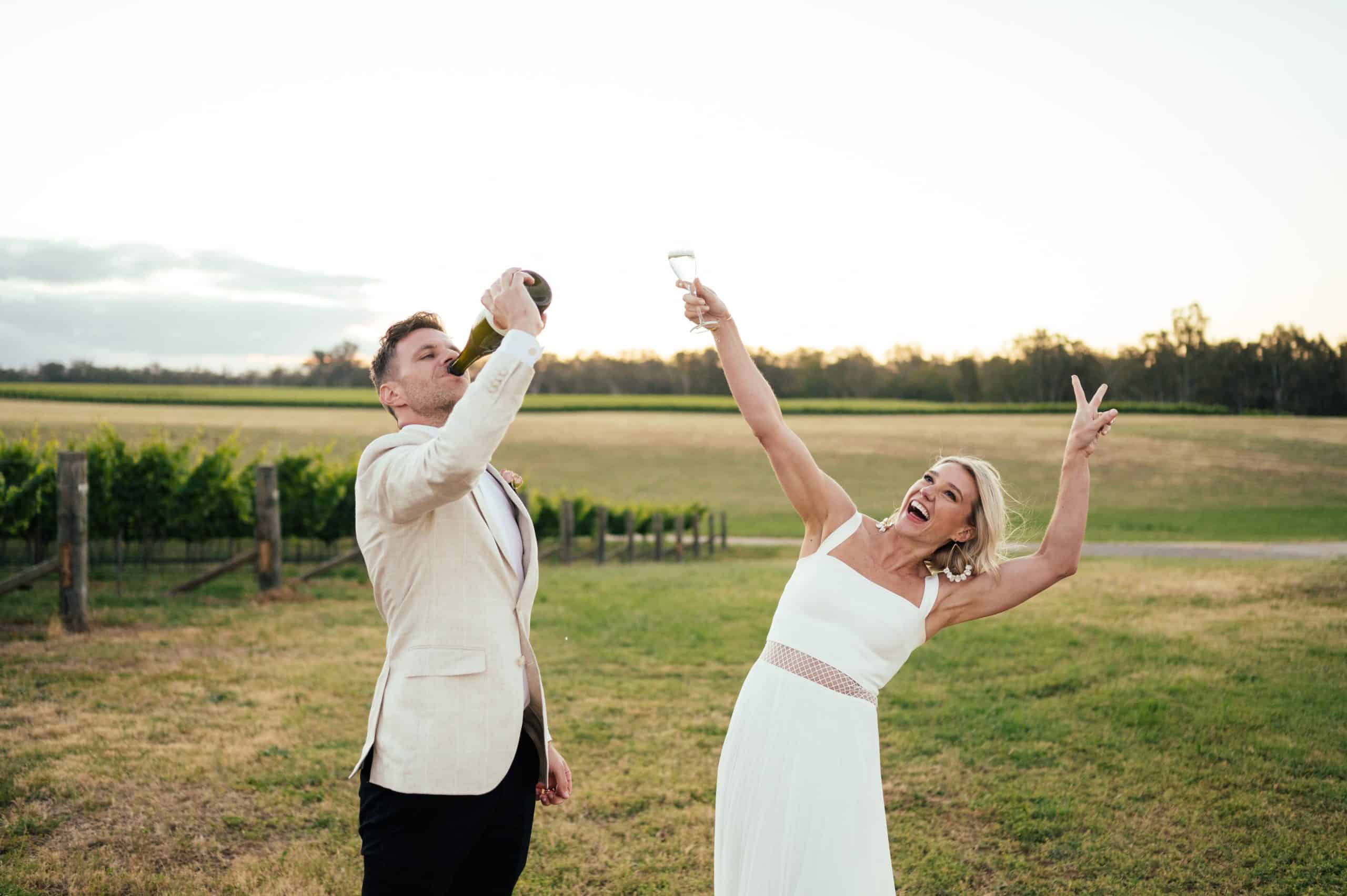 Alex Motta Wedding Photographer Newlyweds with Champagne Bottle at Sunset